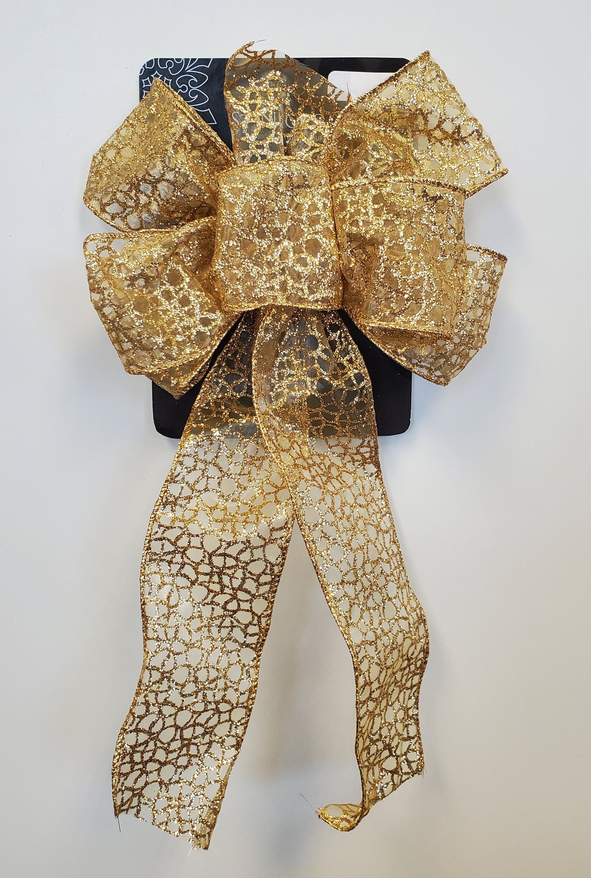 This image shows the gold sheer bow. It has six loops and an intricate shiny gold design.