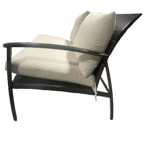 A side profile of an armchair made up of aluminum and wicker