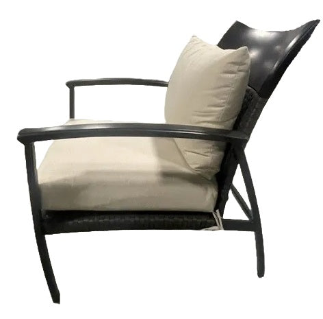 A side profile of an armchair made up of aluminum and wicker