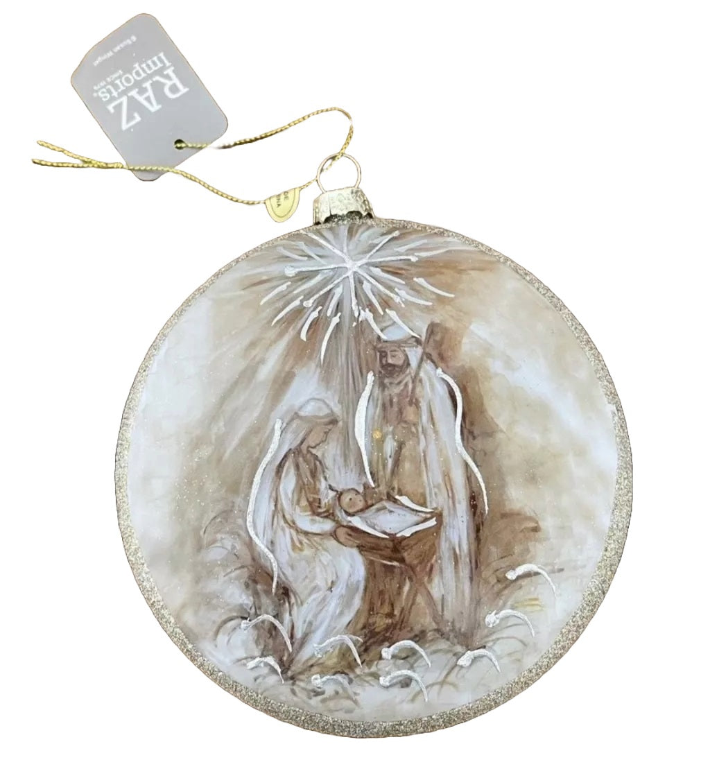 Round disc ornament that features a painted version of the Holy Family in the Nativity Scene with the North Star in the background. The border is covered in gold glitter.