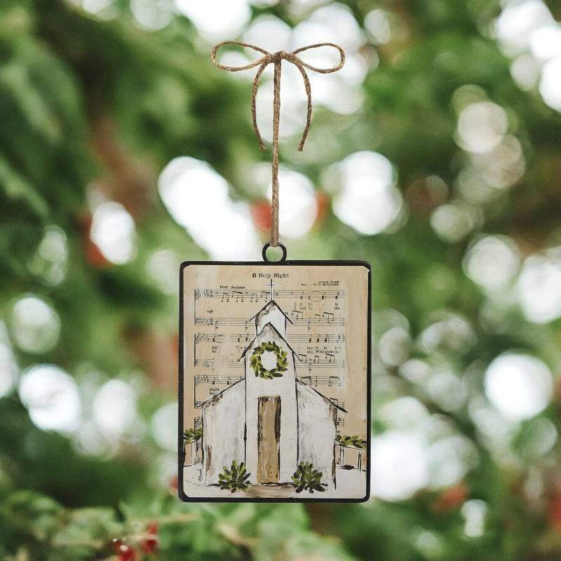 Each ornament features a background printed with sheet music; there are two options. One ornament has the sheet music for "Oh Holy Night" and a chapel with a garland at the steeple. One ornament has the sheet music for "Silent Night" and a chapel with a wreath at the steeple.
