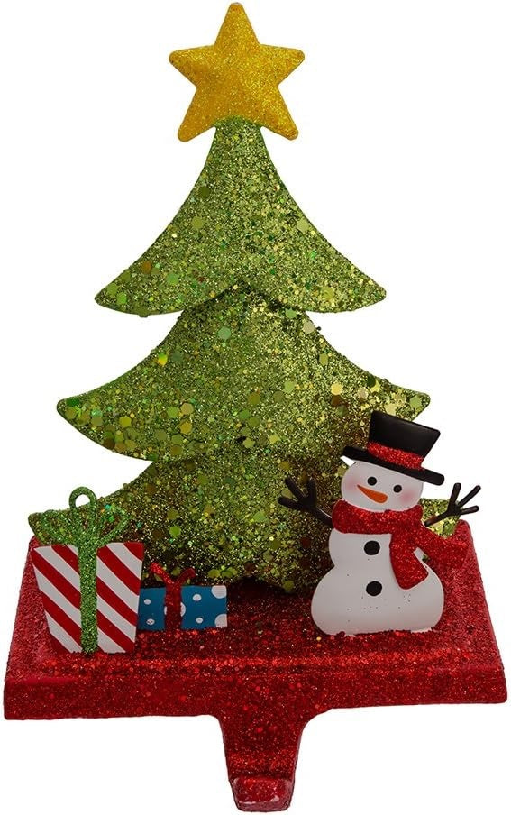Stocking hanger covered in glitter. Designed to look like a light green tree with a yellow star on top. Next to the tree are two presents and a snowman wearing a top hat and a red scarf. The base of the holder is covered in red glitter.