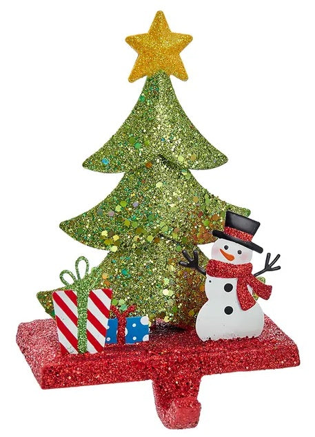 Stocking hanger covered in glitter. Designed to look like a light green tree with a yellow star on top. Next to the tree are two presents and a snowman wearing a top hat and a red scarf. The base of the holder is covered in red glitter.