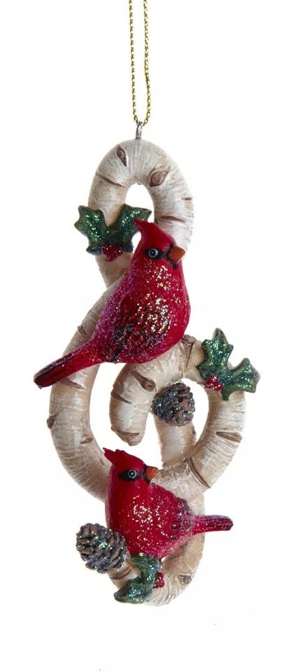 One ornament is shaped like a treble clef. One ornament is shaped like a slanted beamed sixteenth note. Each ornament is designed to look like it's made of birch tree and features glittered holly leaves, berries and pine cone accents.