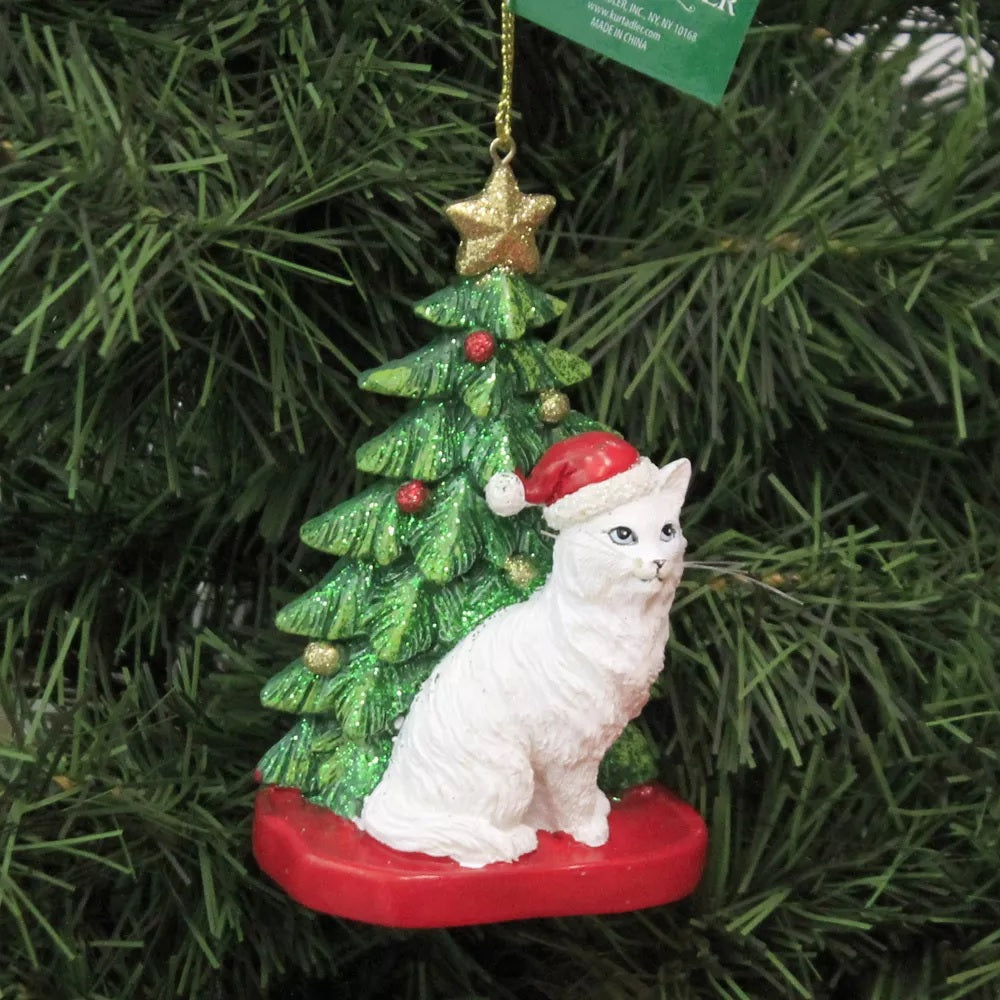 Ornaments shaped like a cat in front of a tree. One ornament features a black and white cat. One ornament features an orange and white cat. One ornament features a light gray and dark gray cat. One ornament features a white cat. All the cats are wearing Santa hats.