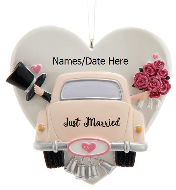 Ornament shaped like a heart with a car in front of it. Also features a top hat, delicate flowers and tin cans trailing behind. Can be personalized.