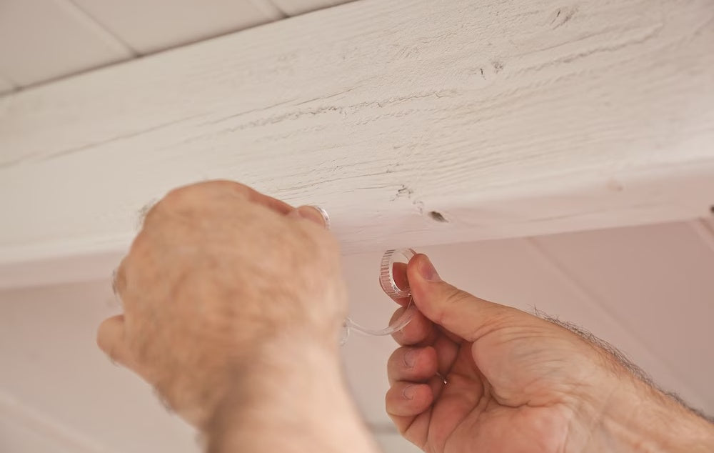 This is a lifestyle image showing someone about to put the clear light clip on a piece of wood.