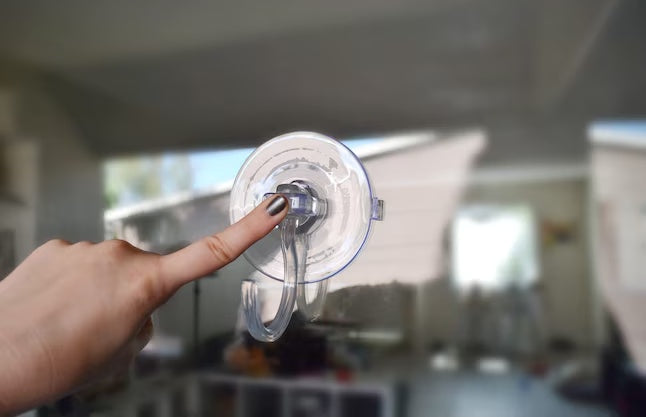 This is a lifestyle image showing how you attach the suction cup to the surface. You press the middle.