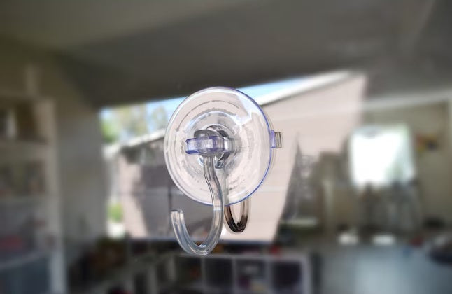 This is a lifestyle image showing the clear clip stuck up against a window.