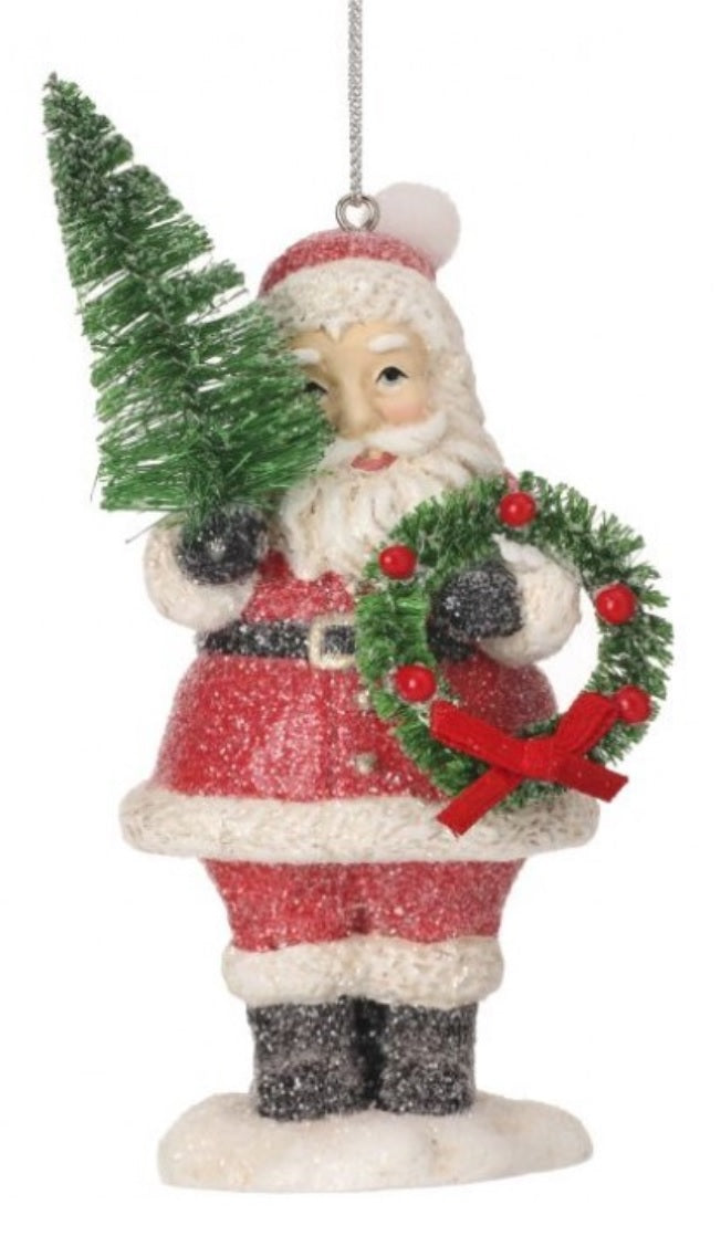 Ornament shaped like Santa Claus holding a small tree and a small, decorated wreath.