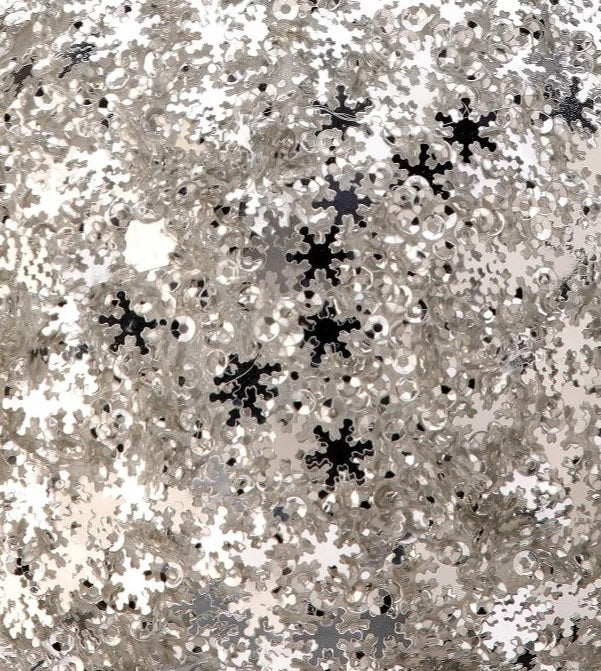 Round ornament covered in silver sequins shaped like snowflakes.