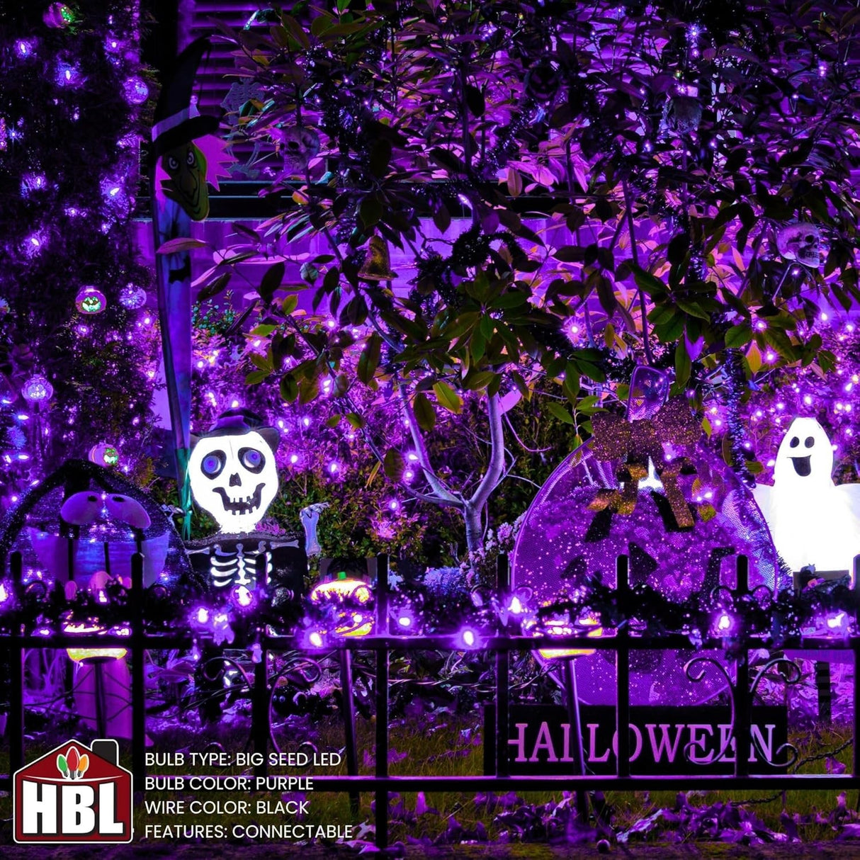This image shows a garden decorated for Halloween with skeleton, pumpkins, ghosts and the purple big seed cluster lights.