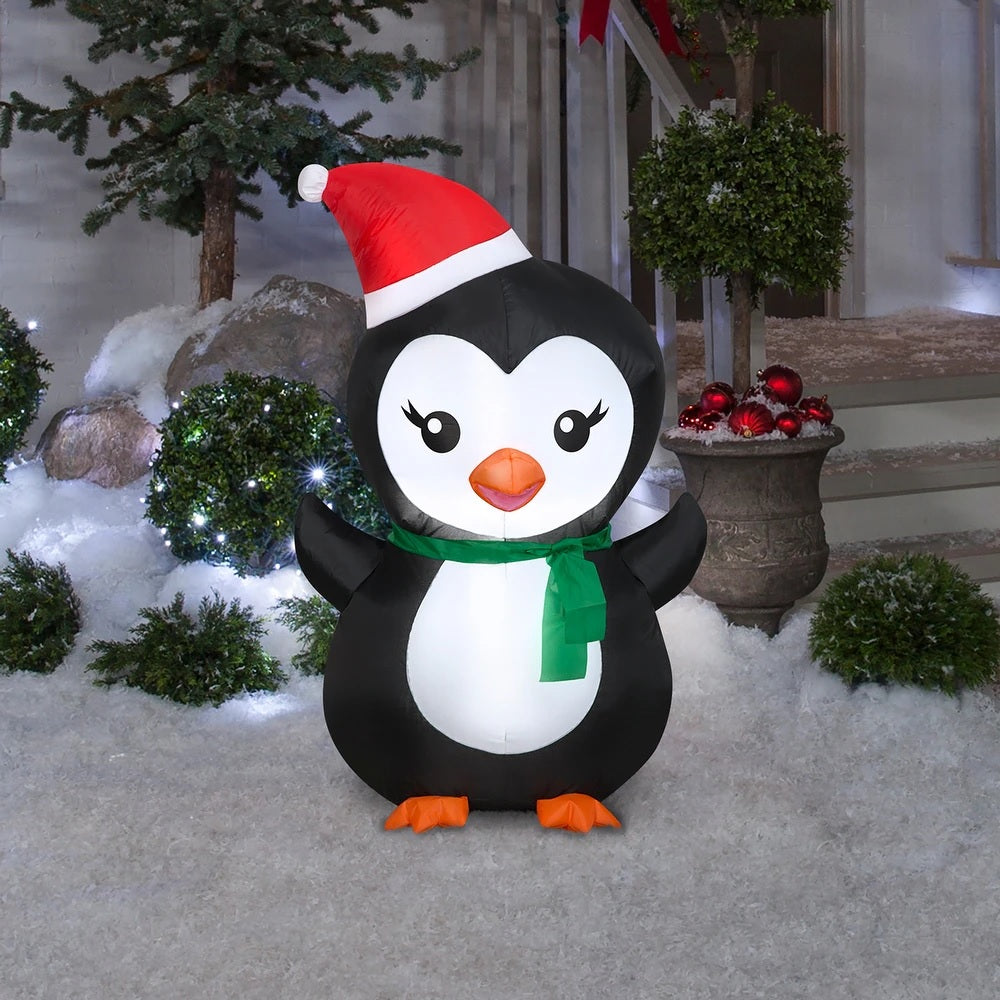 Christmas inflatable designed to look like a cute penguin wearing a Santa hat and a green scarf.