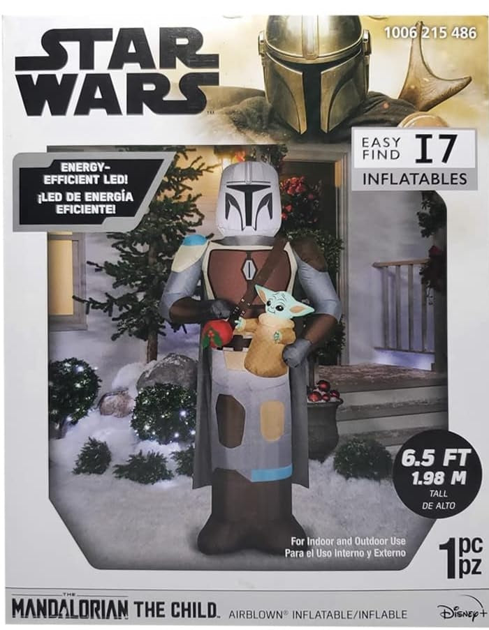 Christmas inflatable designed to look like the Star Wars characters The Mandalorian and Grogu. Mando is holding Grogu and a red holiday ornament.