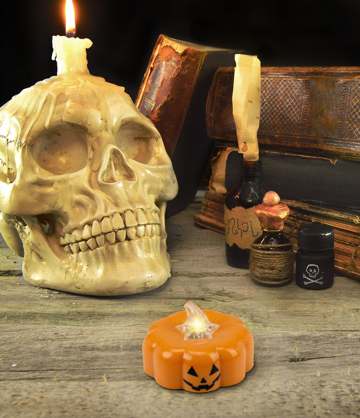This is a lifestyle image showing different Halloween decorations on a table next to the small pumpkin light.