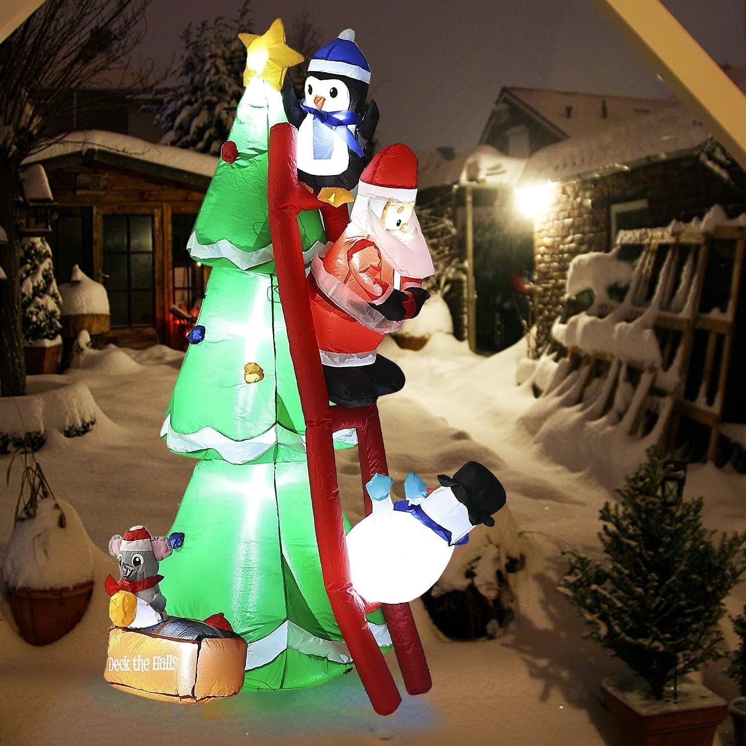 Christmas inflatable shaped like a penguin, Santa and a snowman climbing a red ladder leaning up against a Christmas tree. They're putting the finishing touches on the tree decorating. There's a little box at the bottom with a mouse holding an ornament. The box reads "DECK THE HALLS."