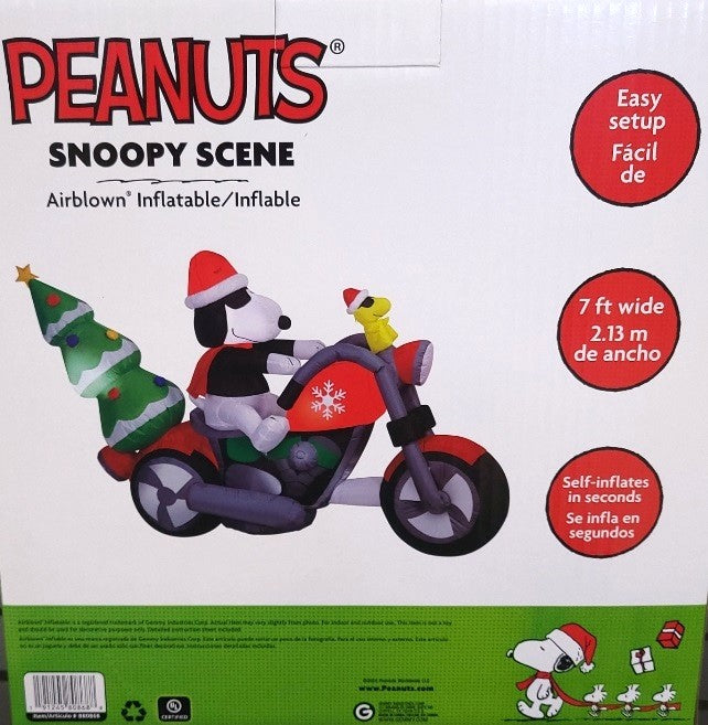 Christmas inflatable. It features Snoopy wearing a Santa hat and wearing sunglasses. Snoopy is driving a red motorcycle with a snowflake accent on it. There's a decorated Christmas tree on the back and Woodstock is riding on the handlebars. There are LED lights inside.