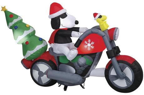 Christmas inflatable. It features Snoopy wearing a Santa hat and wearing sunglasses. Snoopy is driving a red motorcycle with a snowflake accent on it. There's a decorated Christmas tree on the back and Woodstock is riding on the handlebars. There are LED lights inside.