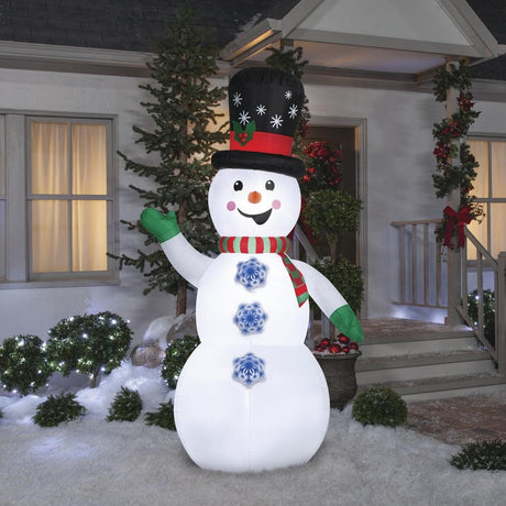 Inflatable snowman wearing a top hat, a red and green striped scarf and green gloves. There are buttons shaped like snowflakes going down his belly. The buttons spin!