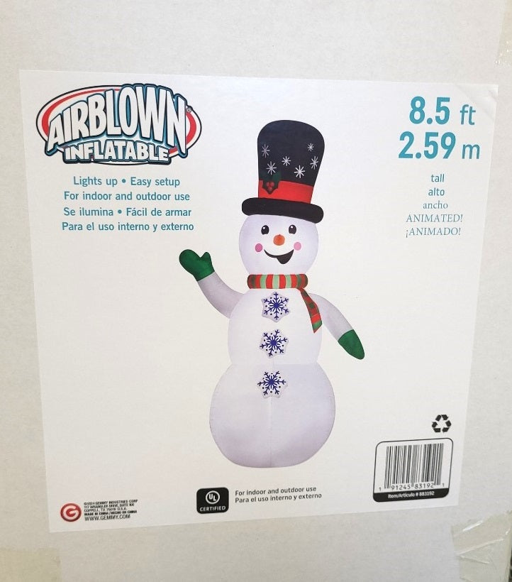 Inflatable snowman wearing a top hat, a red and green striped scarf and green gloves. There are buttons shaped like snowflakes going down his belly. The buttons spin!