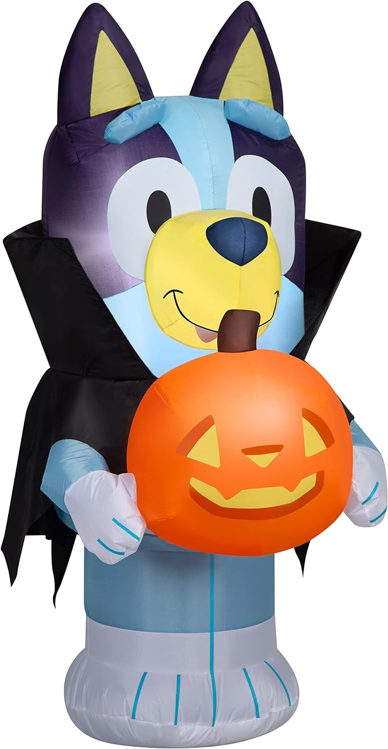 Halloween inflatable shaped like the cartoon character Bluey. He's dressed as a vampire and holding a jack-o-lantern.