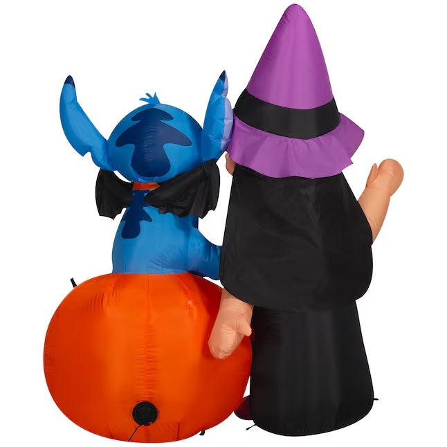 Halloween inflatable shaped like the Disney characters Lilo and Stitch dressed for Halloween. Lilo is wearing a witch costume and Stitch is wearing a collar with bat wings on it. Stitch is sitting on a jack-o-lantern.