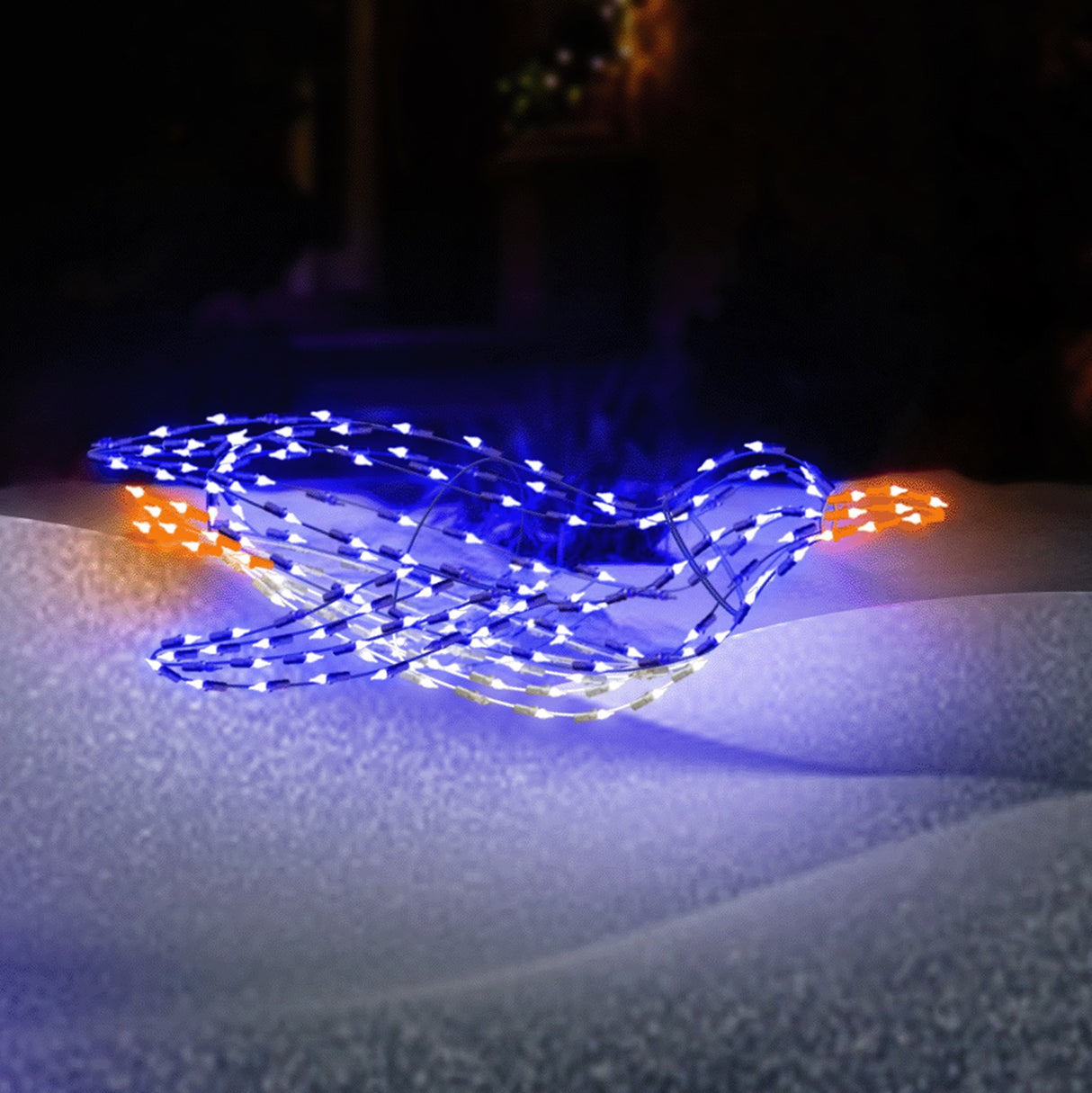 Outdoor LED wire sculpture shaped like a blue penguin sliding. Pre-lit with blue, pure white and orange lights.