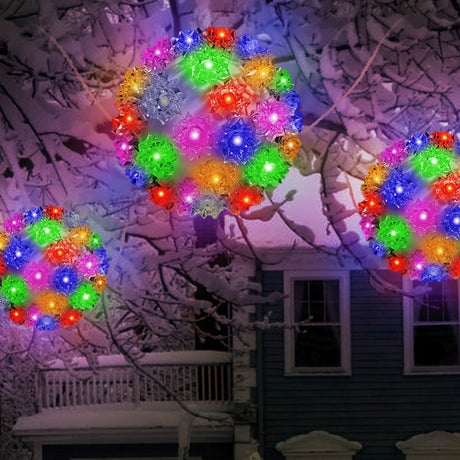 Outdoor lights hanging from snow covered tree branches. The lights are spheres and lit with multi-colored lights.