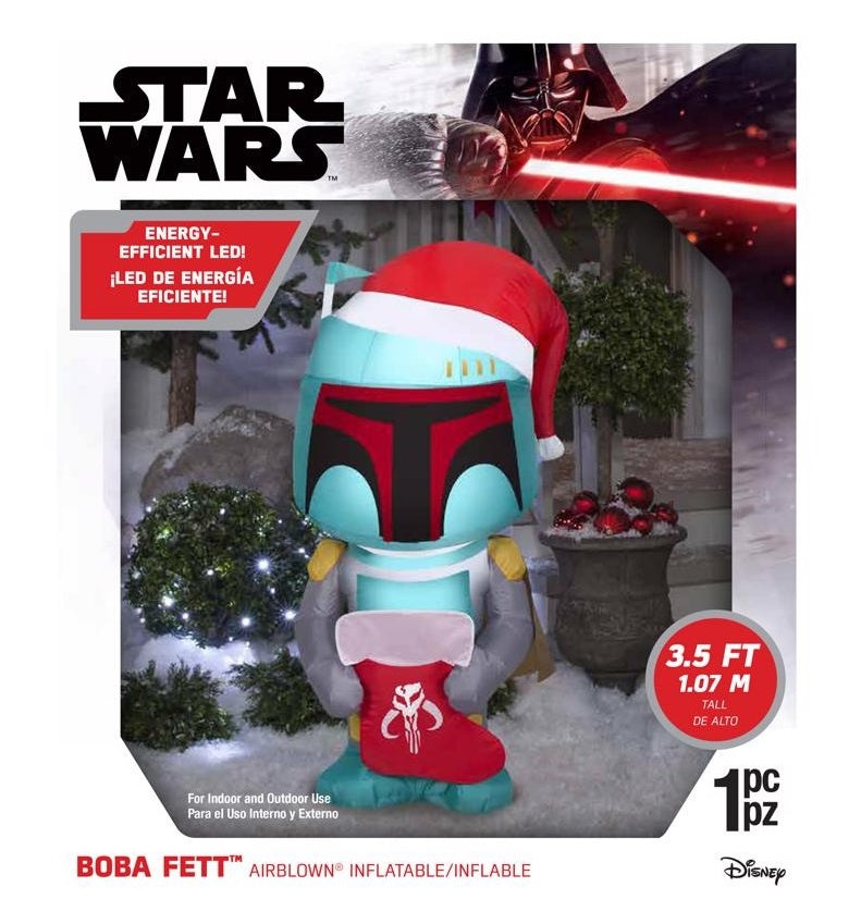 Christmas inflatable designed to look like the famous Star Wars character Boba Fett. He's wearing a Santa hat and holding a stocking with the Mandalorian symbol on it.
