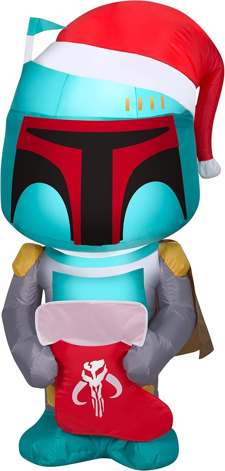 Christmas inflatable designed to look like the famous Star Wars character Boba Fett. He's wearing a Santa hat and holding a stocking with the Mandalorian symbol on it.
