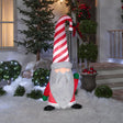 Christmas inflatable shaped like a gnome with a long white beard and a tall, red and white striped Santa hat.