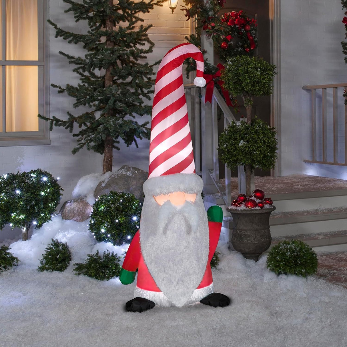 Christmas inflatable shaped like a gnome with a long white beard and a tall, red and white striped Santa hat.