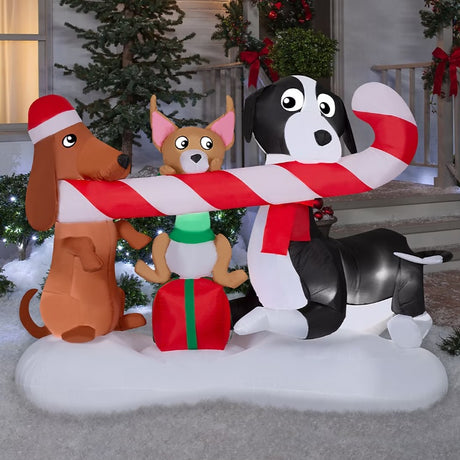 Christmas inflatable designed to look like three dogs sharing a giant candy cane. One dog is wearing a Santa hat, another one is sitting on a present and the third is wearing a red scarf.