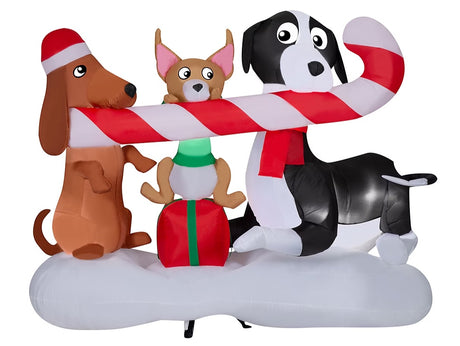 Christmas inflatable designed to look like three dogs sharing a giant candy cane. One dog is wearing a Santa hat, another one is sitting on a present and the third is wearing a red scarf.