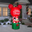 Christmas inflatable shaped like Mickey Mouse dressed as Santa and standing in a hot air balloon basket. The basket is green with a green wreath on it. The balloon is shaped like Mickey's head and ears. The balloon reads "Holiday Greetings!"