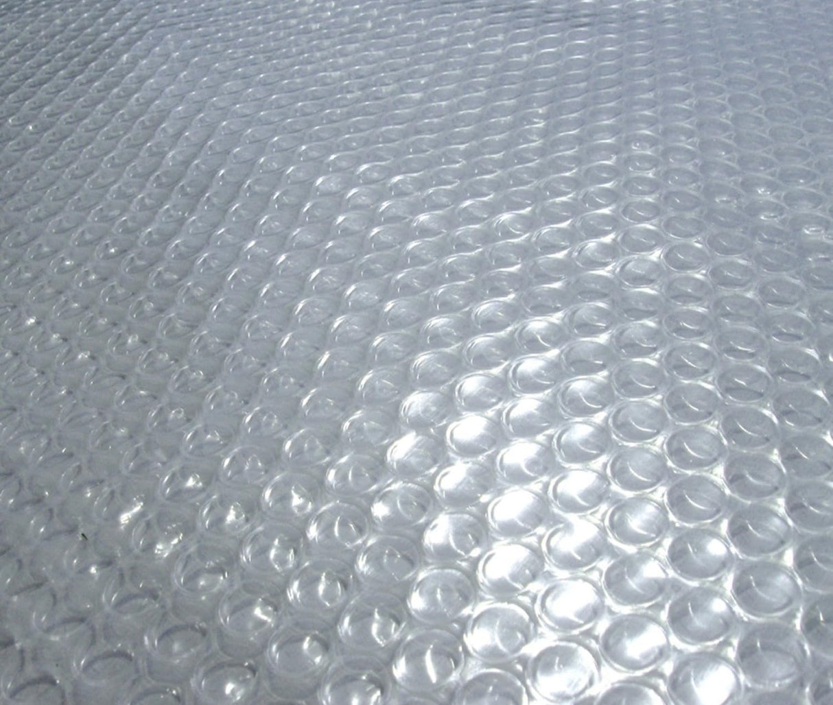 A clear solar pool cover with thousands of tiny air bubbles.
