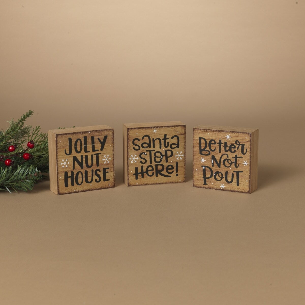 Square shaped holiday sign. One sign reads "Jolly Nut House." One sign reads "Santa Stop Here!" One sign reads "Better Not Pout."