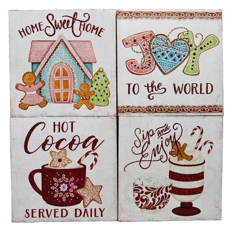 One sign features two gingerbread people outside of a gingerbread house and reads "Home Sweet Home." One sign reads "Joy to the World" and has some gingerbread cookie accents. One sign reads "Hot Cocoa Served Daily" and features a mug with cookies and a candy cane inside. One sign reads "Sip and Enjoy" and features two mugs with different designs.
