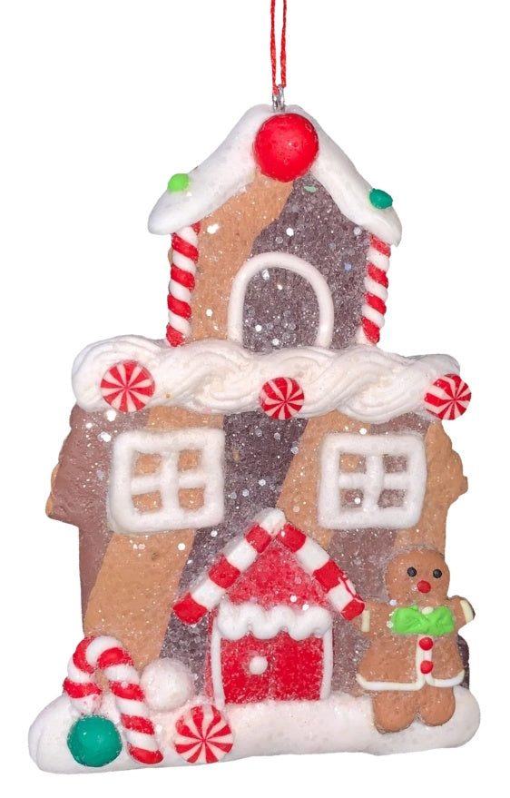 This ornament was designed to look like a gingerbread cookie house covered in sugar. This specific ornament has a tall steeple on the roof and features a candy cane on the left side of the front door and a gingerbread woman on the right side.