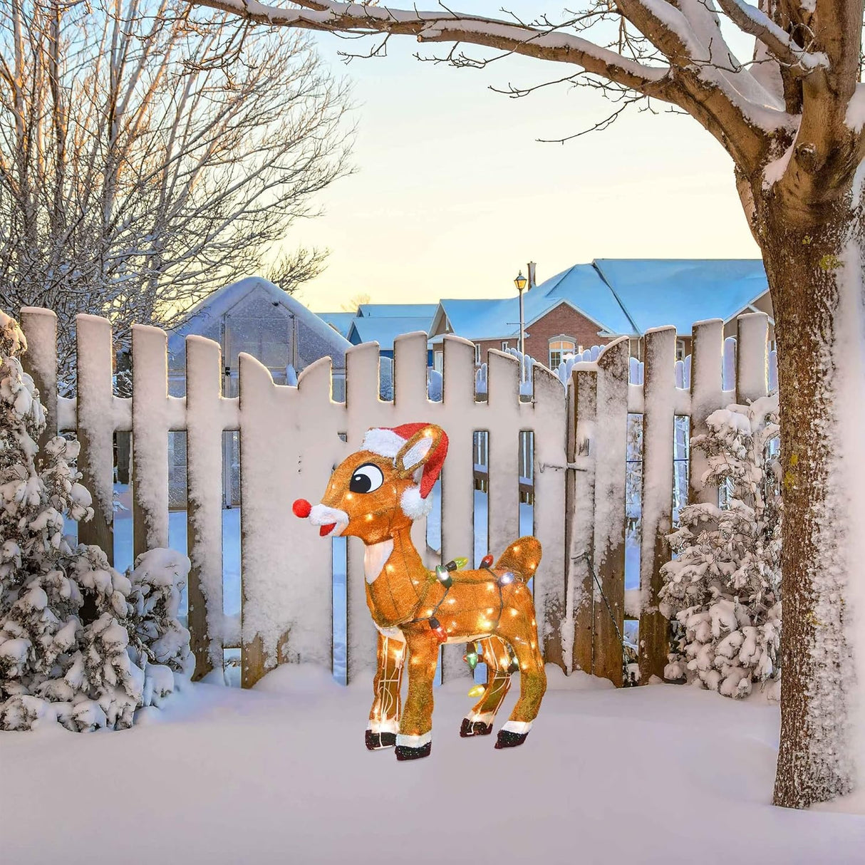 This is a lifestyle image showing the Rudolph wire decoration on a snowy lawn in front of a snowy fence.