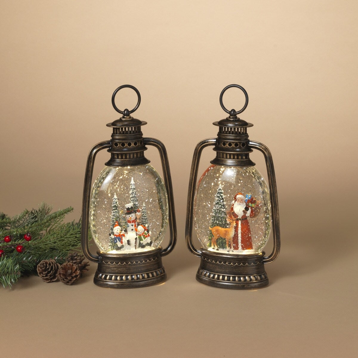 Lighted holiday spinning water globe lantern. One lantern has a snowman family surrounded by trees. One lantern has Santa holding a bag of gifts while standing next to a reindeer and a tree.