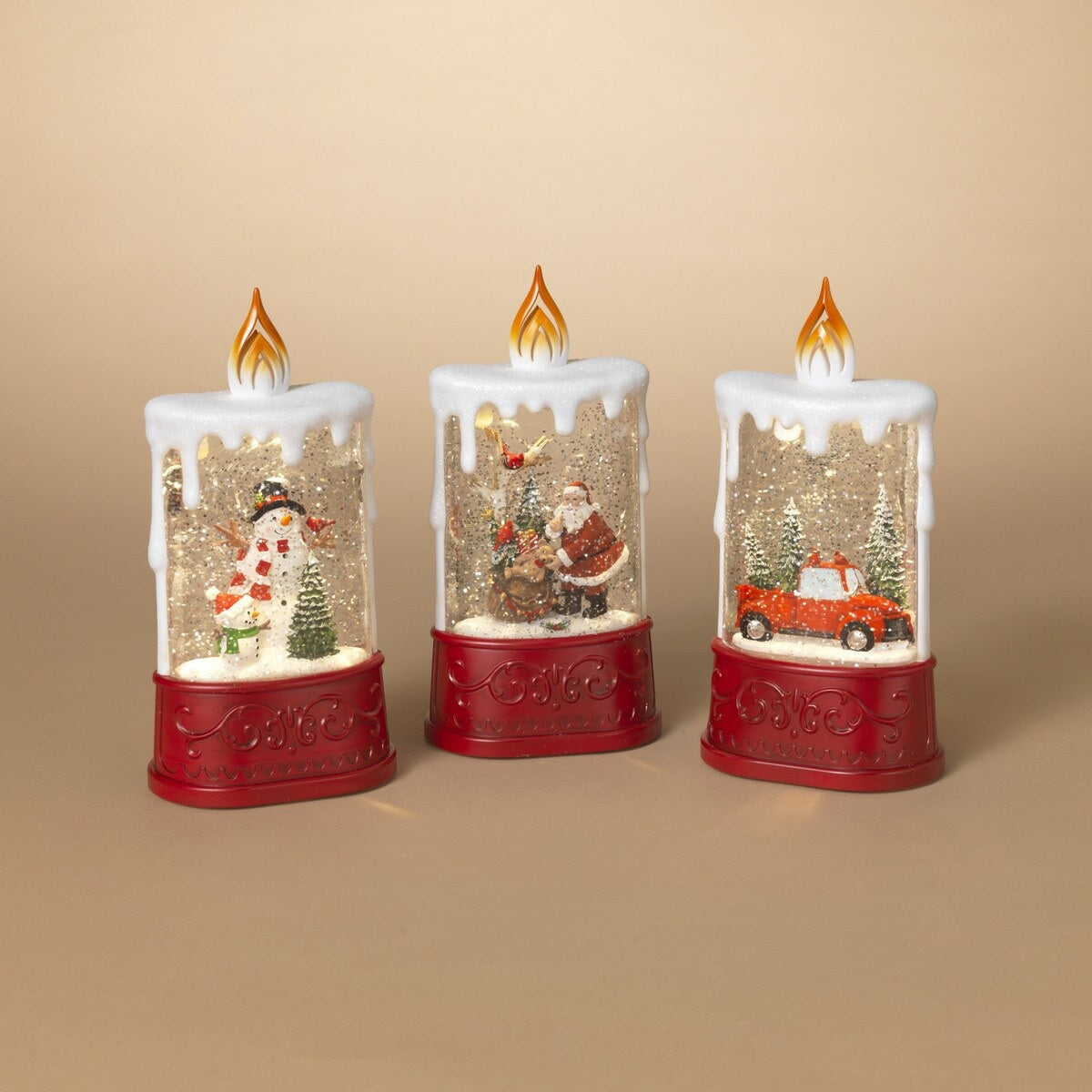 Spinning water globe shaped like a candle. One lantern features two snowmen and a small tree. One lantern features Santa unloading gifts from his bag. One lantern features a red truck surrounded by trees.