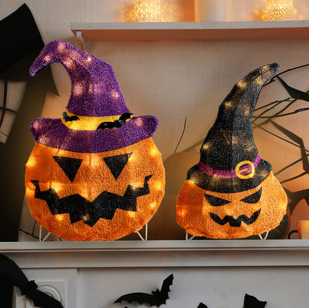 This is a lifestyle image showing these two decorative pumpkins on a mantel in a room decorated for Halloween.