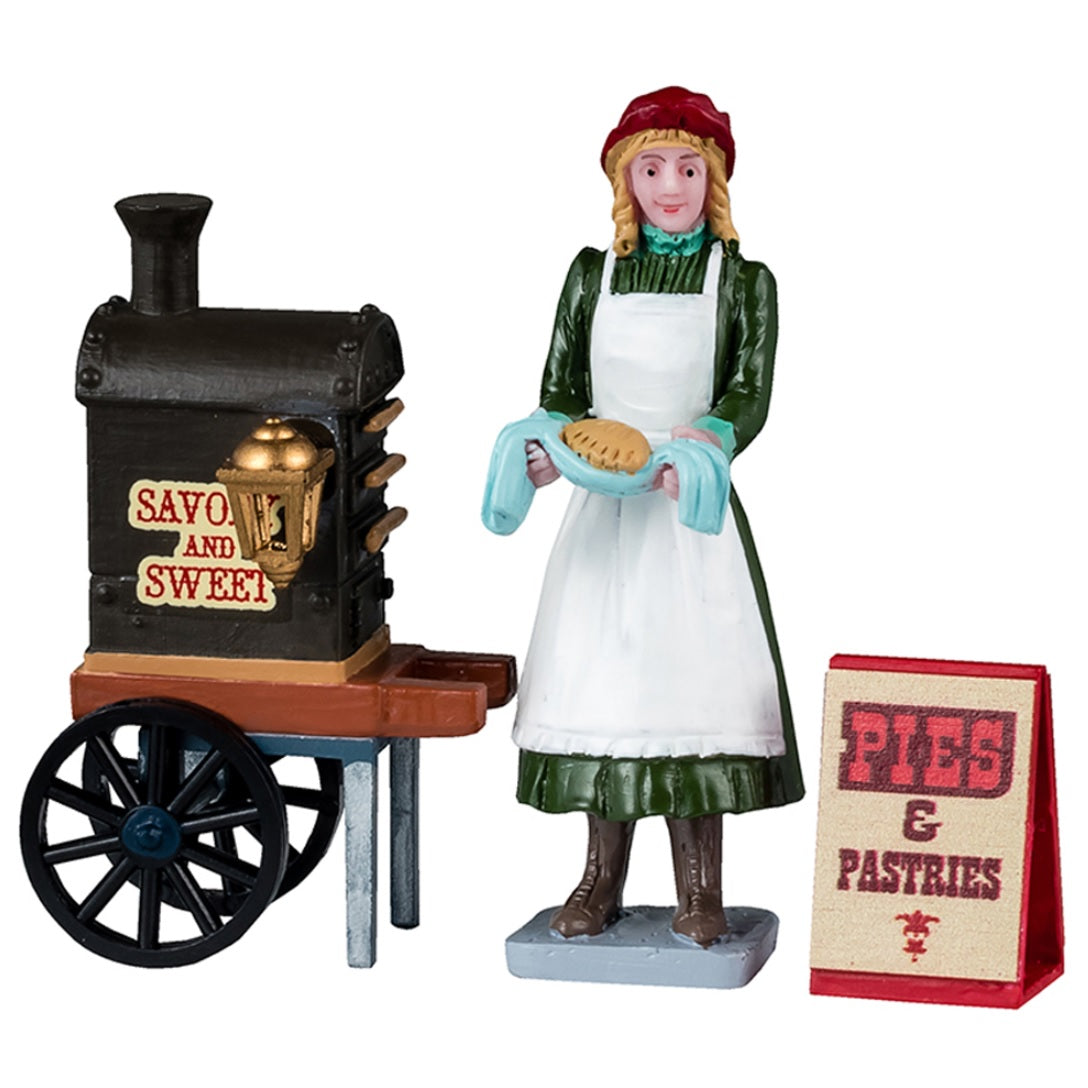 Resin figurines for a Lemax tabletop display. Designed to look like a woman serving pies from a food cart. The cart reads "Savory and Sweet." The sign on the ground reads "Pies & Pastries."