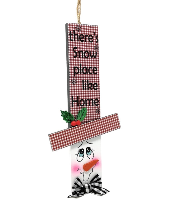 Hanging sign designed to look like a snowman head. One snowman has a red and green buffalo check top hat that reads "Let It Snow." One snowman has a red and green plaid top hat that reads "Come in from the Cold." One snowman has a red and white plaid top hat that reads "There's Snow place like Home."
