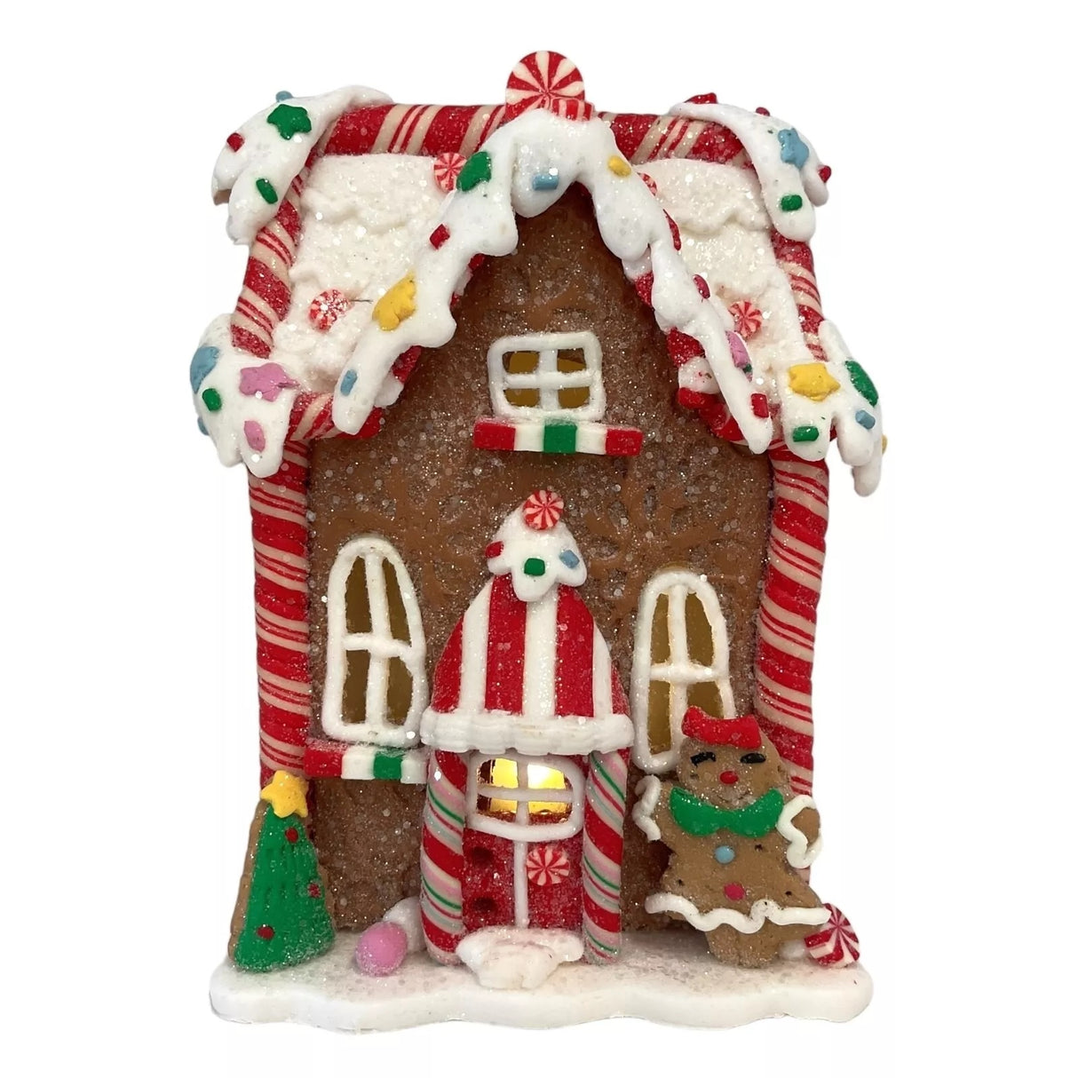 Decorative piece designed to look like a gingerbread covered in candies and frosting. This one has a tree and a gingerbread person near the front door.