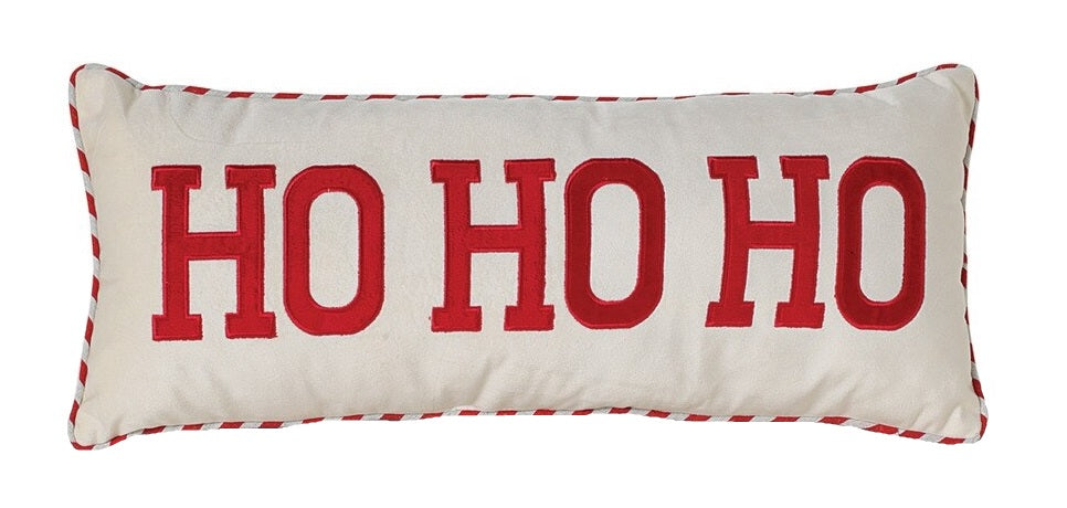 White pillow that reads "HO HO HO" in red, block text. The border is red and white striped.