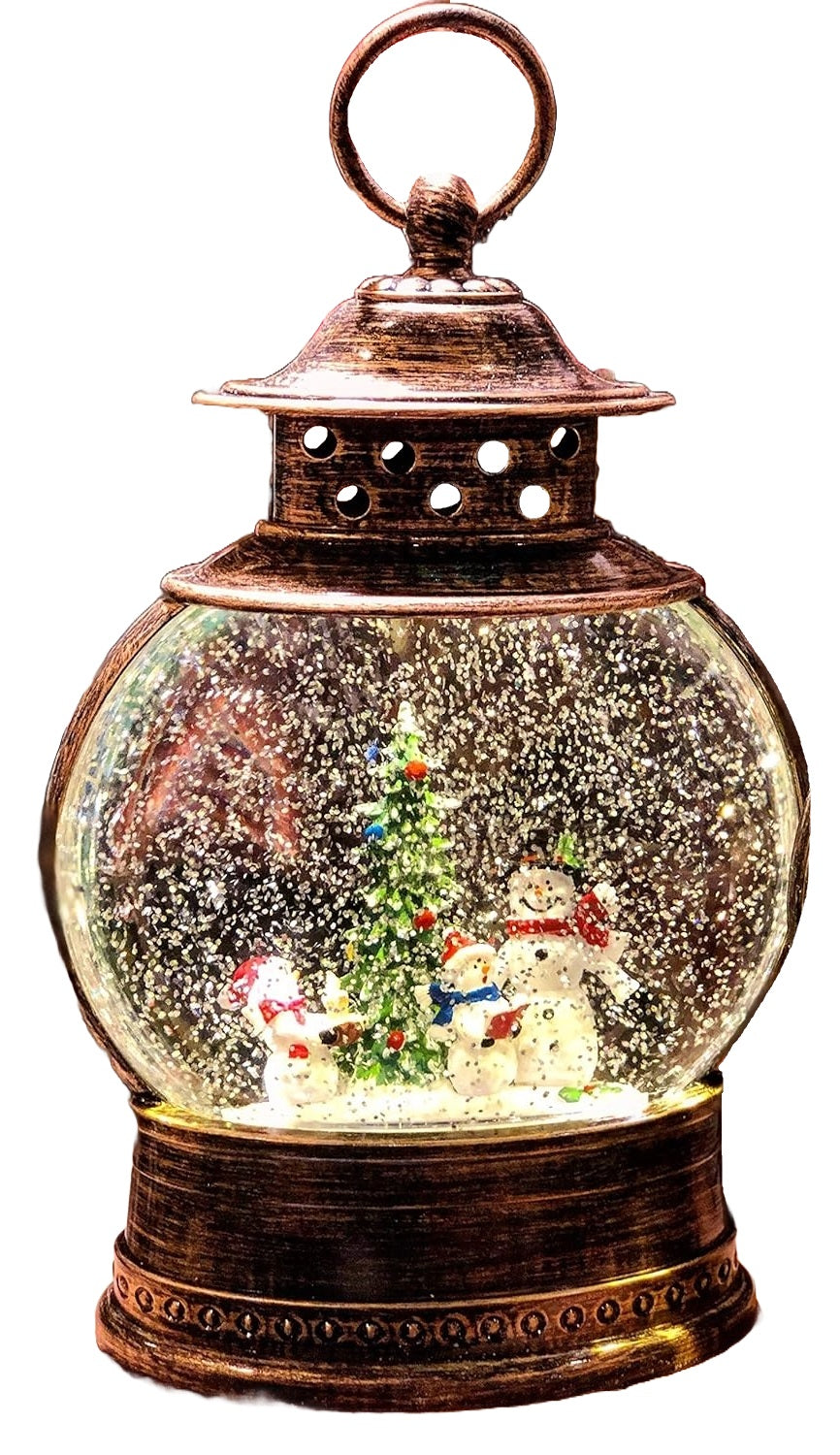 Glass globe lantern tabletop decoration. Inside this lantern is glitter and a winter scene showing three snowmen standing near a decorated tree.
