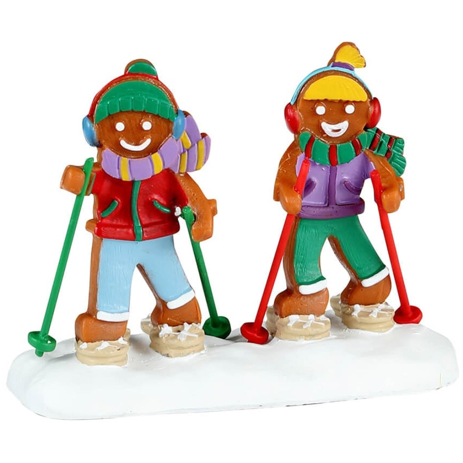Resin figurine for a Lemax display. Designed to look like two gingerbread people walking in the snow with snow shoes on. They're decorated to look like they're wearing winter clothes.