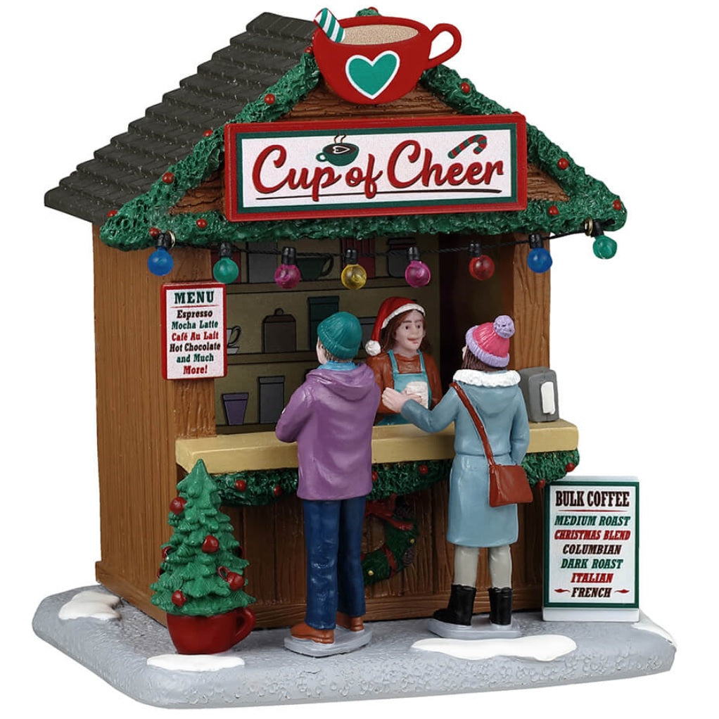 Resin table accent for a Lemax display. Designed to look like a wooden booth that's been decorated for Christmas. The sign reads "Cup of Cheer" and features a large, red mug of coffee with a green peppermint stick hanging out of it. There are multi-colored lights hanging from the roof, along with decorated garland. The vendor behind the counter wears a Santa hat. There are two people ordering drinks. There's snow on the ground and two menus listing what you can order.
